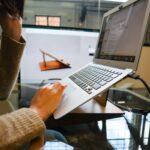 photo of a person using a gray laptop computer